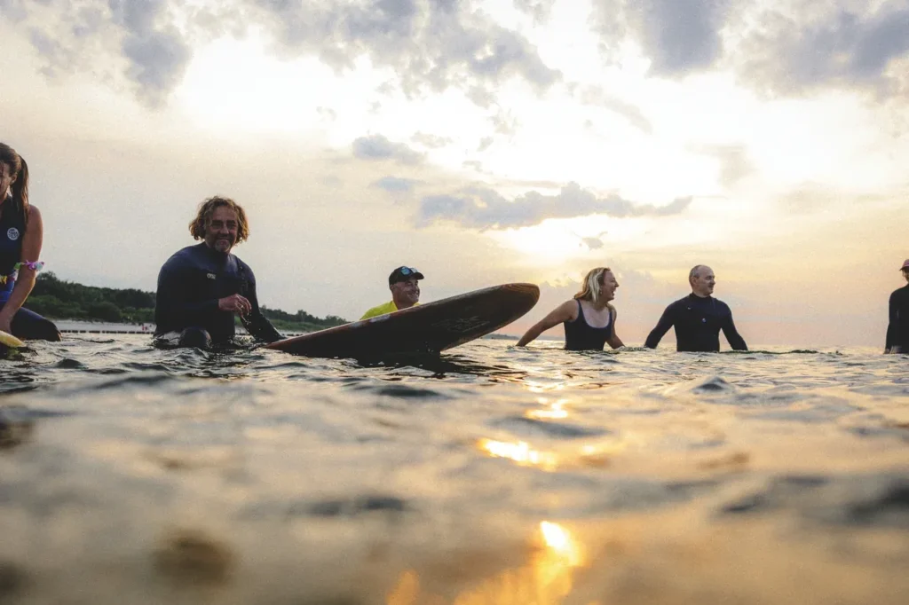 Surferzy na wodzie o zachodzie słońca podczas festiwalu Hel Riders